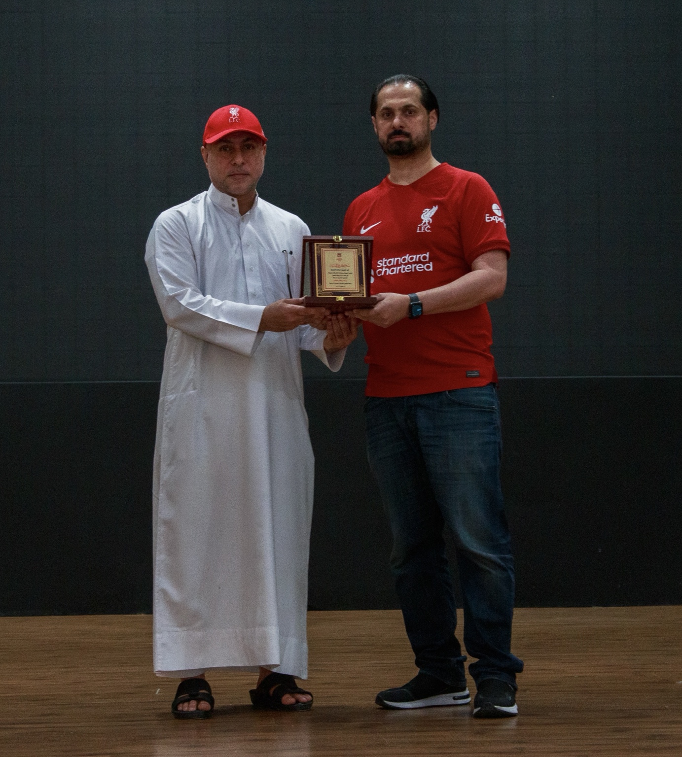 Salah Alshaikh receiving a commemorative shield