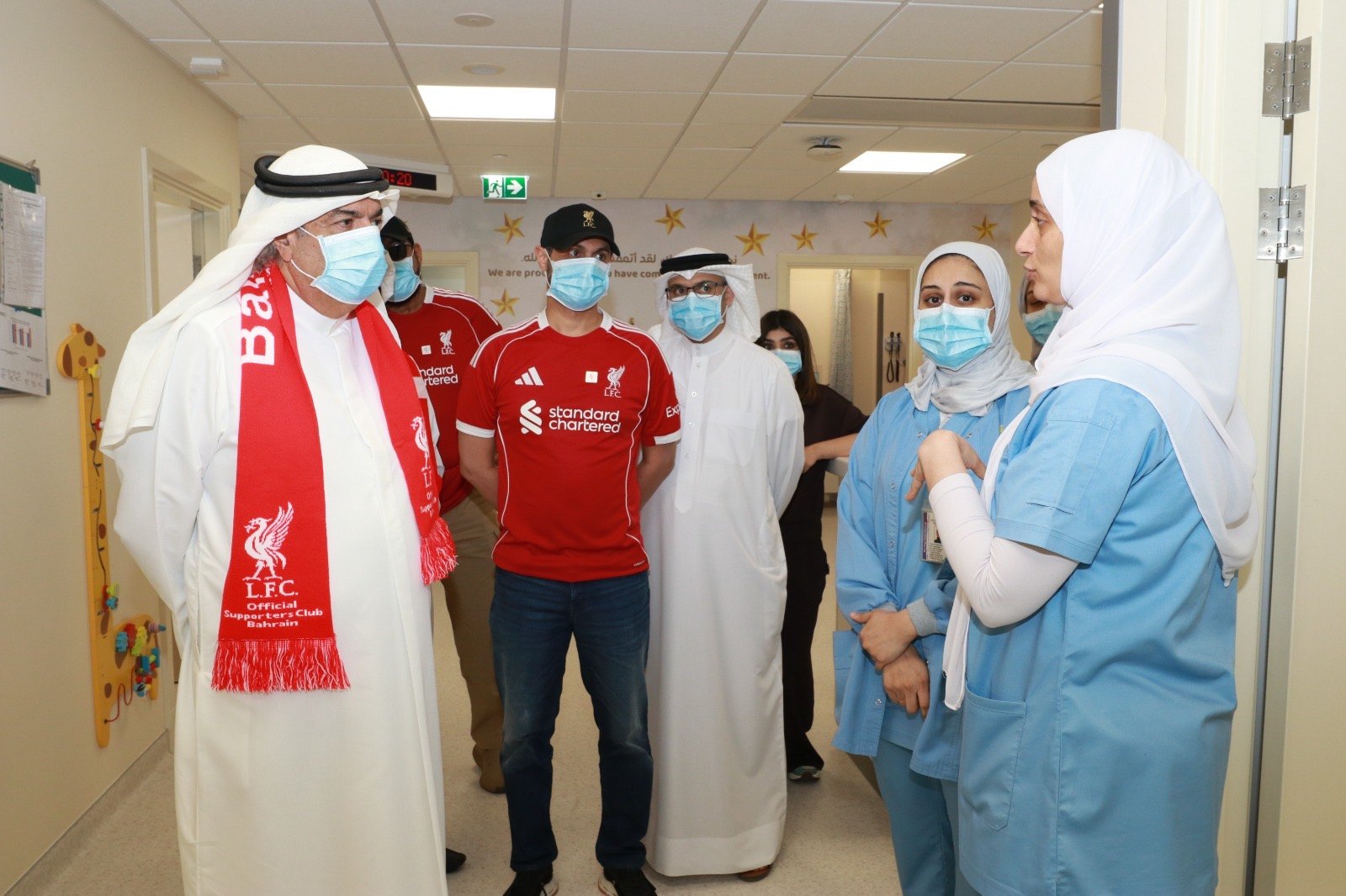 OLSC Bahrain representatives speaking with medical staff in a hospital corridor.