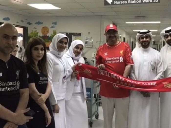 OLSC Bahrain members and hospital staff holding a Liverpool scarf in the children’s ward at Salmaniya Medical Complex.